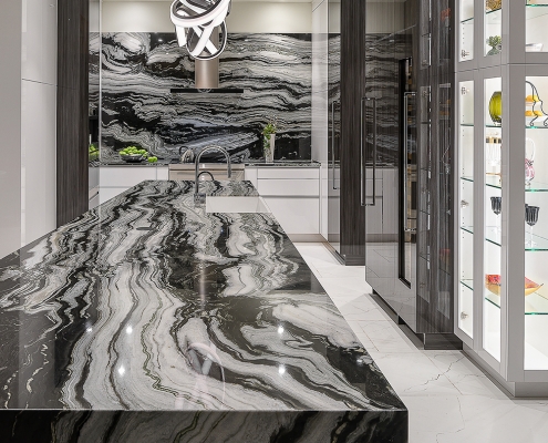 contemporary black and white kitchen with waterfall marble topped island and custom glass display cabinetry, interior design by Kim Gwozdz, Arizona