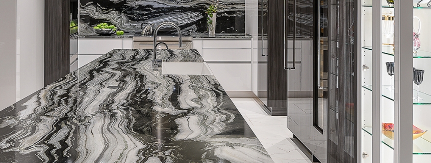 contemporary black and white kitchen with waterfall marble topped island and custom glass display cabinetry, interior design by Kim Gwozdz, Arizona